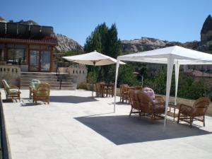 a patio with chairs and tables and umbrellas at Nature Park Cave Hotel in Goreme