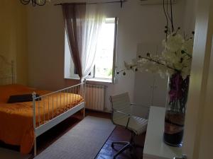 een slaapkamer met een bed en een vaas met bloemen bij Tenuta Le Fornacelle in Torre del Greco
