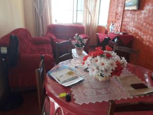 una mesa con un mantel rojo y flores en ella en Apartamento Ed Jany Fortaleza, en Fortaleza