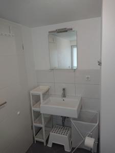 a white bathroom with a sink and a mirror at Zur alten Schmiede in Ladelund