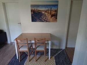 a dining room table with two chairs and a picture on the wall at Zur alten Schmiede in Ladelund