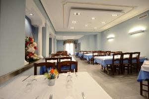 comedor con mesas y sillas y paredes azules en Hotel Duque de Calabria, en Manzanera