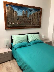 a bedroom with a blue bed with a painting on the wall at Roma Papalina in Rome
