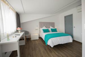 a bedroom with a bed with blue pillows and a desk at Hotel Duque de Calabria in Manzanera