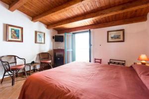 a bedroom with a large red bed and chairs at Le Piccole Grotte in Scilla