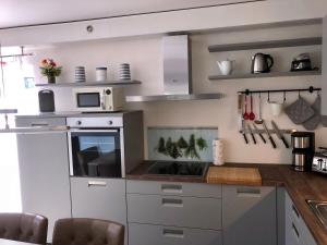 a kitchen with white cabinets and a microwave at Ferienhaus Traumspot in Wiek auf Rügen