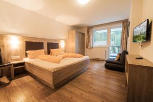 a bedroom with a large bed and a large window at Aurora Appartements in Neustift im Stubaital