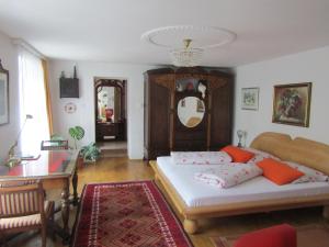 a bedroom with a bed and a table and a mirror at Villa Kreuthhof Appartements in Klosterneuburg