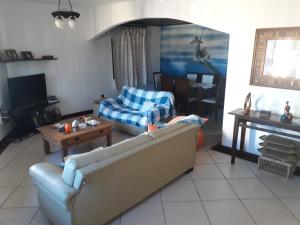 sala de estar con sofá y mesa en Casa Triplex Arraial do Cabo, en Arraial do Cabo