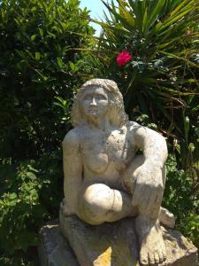 a statue of a woman sitting on a rock at les alicantes in Coursan +6 photos