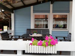 un porche con una mesa y flores en Ferienhaus Leja, en Beschendorf