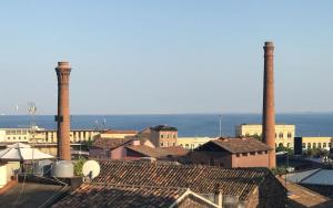 a city with two tall chimneys on top of roofs at Holiday In Home | Le Ciminiere in Catania