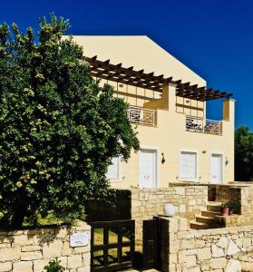 ein Haus mit einer Steinmauer und einem Baum in der Unterkunft Princess Of Crete in Skaleta