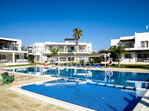a large swimming pool with chairs in front of a building at Villa Lilach - Seaside, Caesar Beach in Boghaz