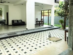 a living room with a couch and a tile floor at Opal Mirissa in Mirissa
