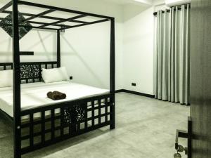 a bedroom with a bed with a cat laying on it at Opal Mirissa in Mirissa