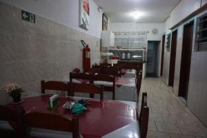 a dining room with tables and chairs in a restaurant at Pousada Orquidário in Santos
