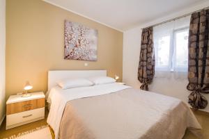 a bedroom with a white bed and a window at Long Island Olive Apartment in Sali