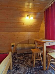 a log cabin with a bed and a table at Willa u Kubusia in Zakopane