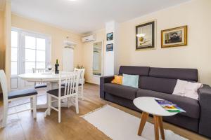 a living room with a couch and a table at Long Island Olive Apartment in Sali