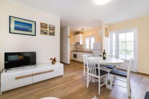 a kitchen and dining room with a table and a tv at Long Island Olive Apartment in Sali +40 photos