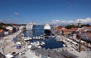 a group of boats docked in a harbor with a cruise ship at Nordhagen 17 in Stavanger