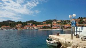 a boat is docked at a dock in a harbor at Long Island Olive Apartment in Sali