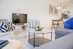 a living room with a blue couch and a table at Apartamenty Nad Żylicą przy deptaku - Dream Apart in Szczyrk +14 photos