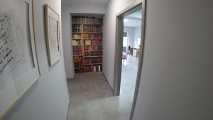 a hallway with a mirror and a library of books at Apartamenty Kozienice in Kozienice