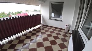 a hallway with a checkered floor and a window at Apartamenty Kozienice in Kozienice