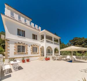 a large white villa with a large patio at Amalia Country House in Áno Yerakaríon
