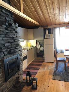 a kitchen with a stone fireplace in a room at Villa Karhunkehto in Luosto +129 photos