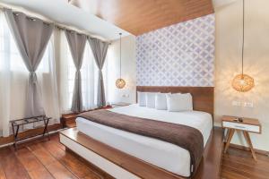 a hotel room with a bed and windows at Quinta Margarita - Boho Chic Hotel in Playa del Carmen +63 photos