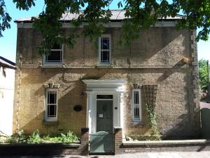 une vieille maison en briques avec une porte verte dans l'établissement The Hayloft, à Hornsea