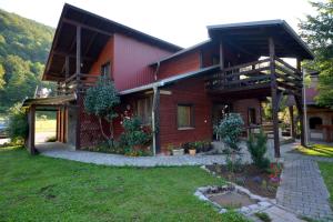 een groot houten huis met een tuin ervoor bij Villa Una Dvoslap in Bihać