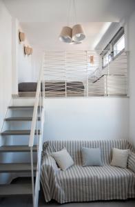a living room with a couch and a staircase at Axos Apartments in Hersonissos