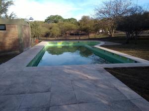 a pool of water in a yard with a patio at Complejo Megevand in Río Ceballos