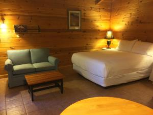 a bedroom with a bed and a chair in a room at Winthrop Mountain View Chalets in Winthrop