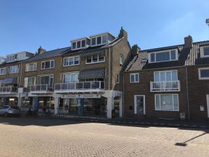 ein großes Backsteingebäude mit Balkonen auf einer Straße in der Unterkunft Casa del Cisne 2 in Zandvoort