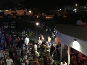 a crowd of people at a party at night at Au Coeur du Village Naturiste in Cap d'Agde