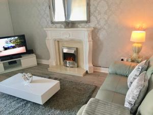 a living room with a fireplace and a couch at RIVER CLYDE VIEWS - PRIVATE & SPACIOUS APARTMENT in Port Glasgow