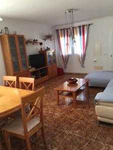 a living room with a couch and a table at Chalet Son Serra in Son Serra de Marina