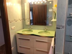 baño con lavabo verde y espejo en Chalet Son Serra, en Son Serra de Marina