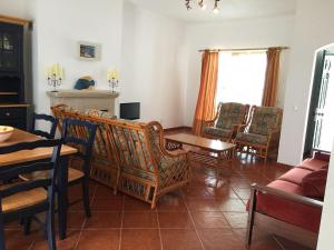 カストロ・マリンにあるPrestige for Home - Moradia Alagoa Praia - Alturaのリビングルーム(テーブル、椅子付)
