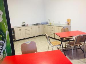 a kitchen with a red table and chairs at Batumi Hotel in Batumi