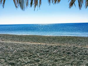 an empty beach with the ocean in the background at Ktima Tzaneti in Lachania