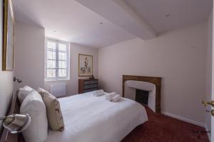 ボーヌにある12 Carnot - Beauneのベッドルーム(白いベッド1台、暖炉付)
