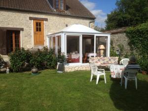 une personne assise dans une cour avec une table et des chaises dans l'établissement Résidence La Beauceronne, à Ouarville