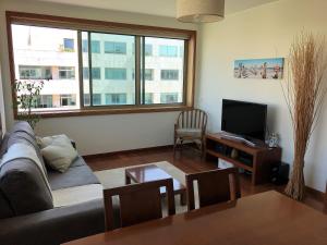 een woonkamer met een bank en een tv bij Love Sea Apartment in Leça da Palmeira