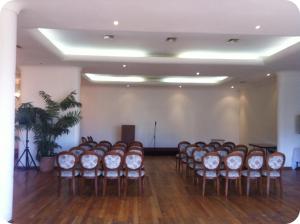 a room with a bunch of chairs in a room at Hotel Montecarlo Viña del Mar in Viña del Mar